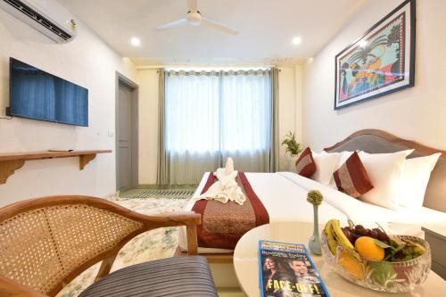 a hotel room with a bed and a table with a bowl of fruit at Tiaraa Lite A Ganges Retreat in Shivpuri