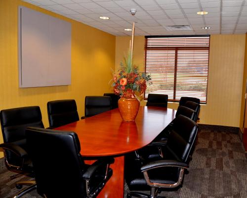 a conference room with a wooden table and chairs at Wingate by Wyndham West Monroe in West Monroe