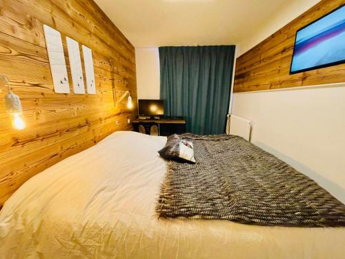 - une chambre avec un lit et un mur en bois dans l'établissement 3 pièces modernes avec parking et wifi à Tignes - FR-1-641-84, à Tignes