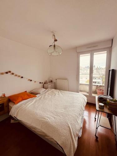 une chambre blanche avec un lit et une fenêtre dans l'établissement Bel appartement proche Mulhouse - grand balcon 9m2, à Pfastatt