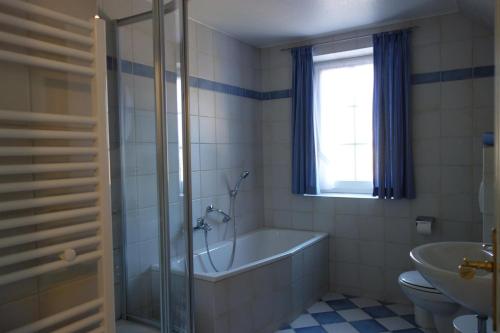 a bathroom with a tub and a toilet and a sink at Haushälfte Luv und Lee in Tating