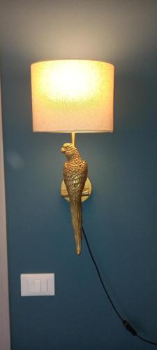 a lamp with a bird on a blue wall at Novecento in Bertinoro