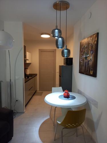 a kitchen with a white table and chairs in a room at Novecento in Bertinoro