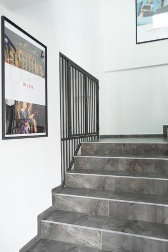 a set of stairs in a white room with a picture at SI apartments - Smart Inn in Vienna