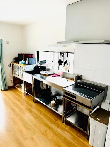 a kitchen with stainless steel appliances and a wooden floor at にいのうみ in Tosa