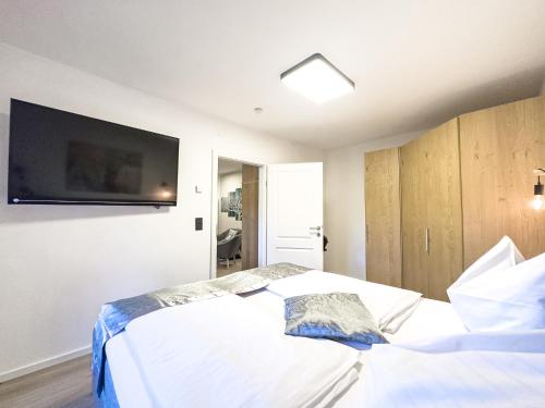 a bedroom with a bed with a tv on the wall at Chihuahua's Ötscher Apartment, but people are also very welcome in our eco-friendly resort! in Lackenhof