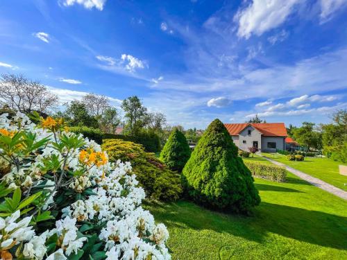 a garden with flowers and trees and a house at U HRÁDKU Superior in Znojmo