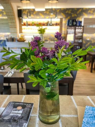 a vase filled with purple flowers sitting on a table at U HRÁDKU Superior in Znojmo