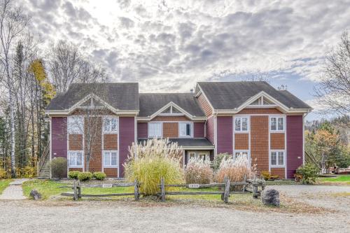 a house with a fence in front of it at Cozy Chalet on the 9th Hole La Bête Pool Golf in Mont-Tremblant
