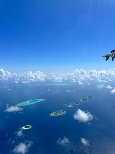 an airplane flying over a group of islands in the ocean at Kendhoo holidays in Kendhoo