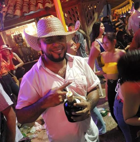 un hombre que lleva una camisa rosa y un sombrero de vaquero en mar azul, en Cartagena de Indias