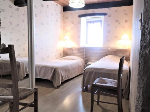 - une chambre avec 2 lits, 2 chaises et une fenêtre dans l'établissement GITE Piscine CAHORS, à Aujols