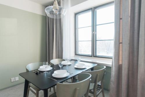 a dining room with a table and chairs and a window at Forenom Aparthotel Jyväskylä in Jyväskylä