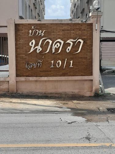 a sign on the side of a brick wall at Nakara Place บ้าน นาครา in Ban Rang Pho