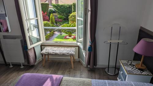 - une chambre avec une fenêtre donnant sur un jardin dans l'établissement Logement sur jardin à Fontainebleau, à Fontainebleau
