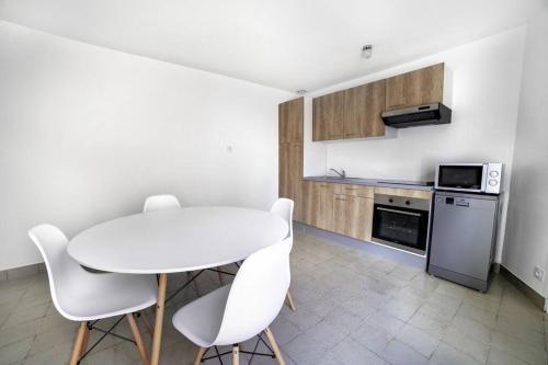 a kitchen with a white table and white chairs at PICH Grande maison centre-ville in Thouars
