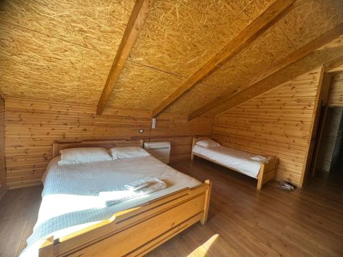 a bedroom with a bed in a wooden cabin at BioFarm Gramsh in Kodovjat