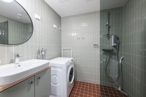 a bathroom with a washing machine and a sink at Forenom Aparthotel Jyväskylä in Jyväskylä