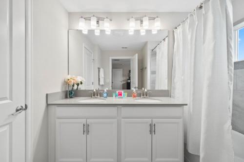 ein Badezimmer mit zwei Waschbecken und einem großen Spiegel in der Unterkunft 900 Pebble Beach Drive in Kissimmee