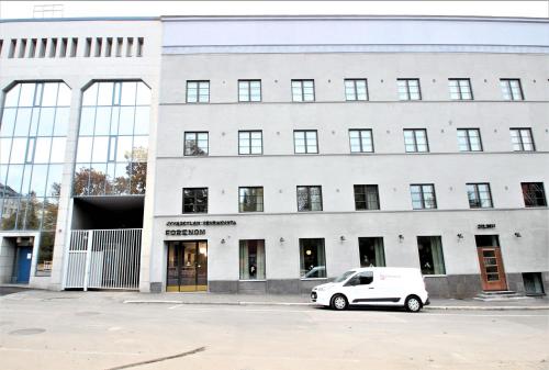a white car parked in front of a building at Forenom Aparthotel Jyväskylä in Jyväskylä