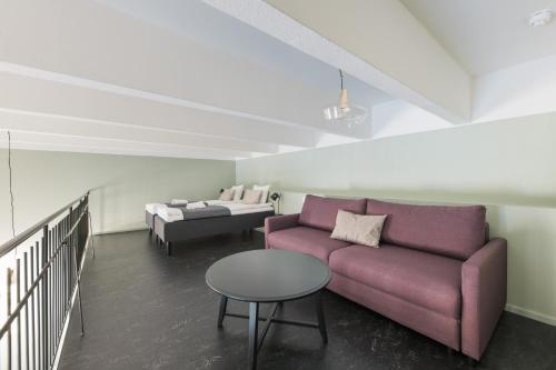 a living room with a purple couch and a table at Forenom Aparthotel Jyväskylä in Jyväskylä