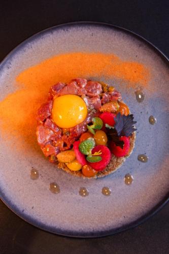 a plate of food with an egg on top at MERICI Hotel Sittard in Sittard