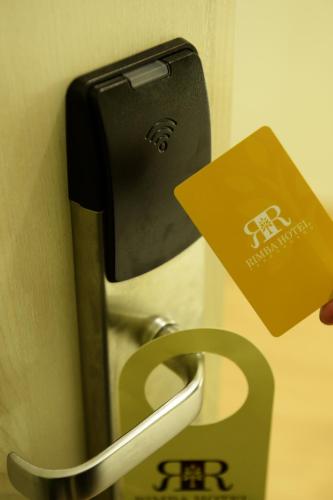 a person holding a card and a door handle at Rimba Hotel in Kuala Terengganu
