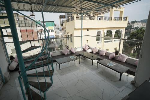 a balcony with a table and benches on a building at Hostel Funky Bunky in Udaipur