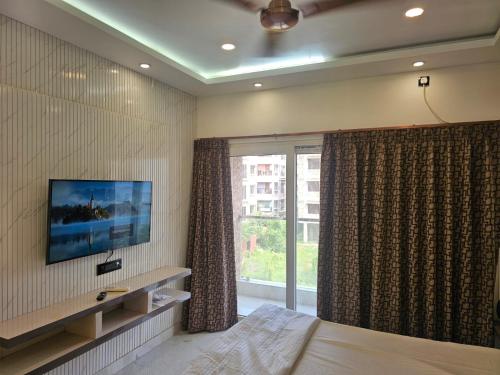 a bedroom with a bed and a tv and a window at LUXE Lagoon in kolkata