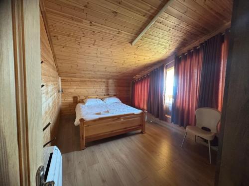 a bedroom with a bed in a wooden room at BioFarm Gramsh in Kodovjat