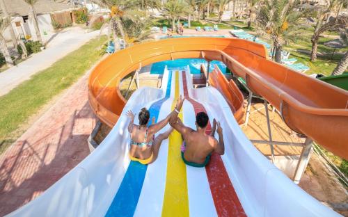 two people on a water slide at a water park at Welcome Meridiana in Djerba