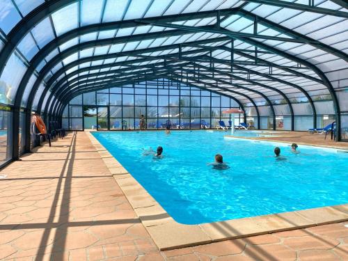 grupa ludzi pływających w basenie w obiekcie Camping la Corniche w mieście Plozévet