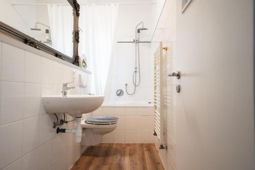 a bathroom with a sink and a toilet and a window at Gästezimmer Kalb in Schweinfurt