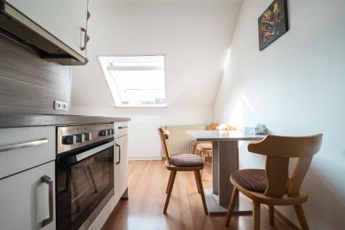 a kitchen with a stove and a table with chairs at Gästezimmer Kalb in Schweinfurt