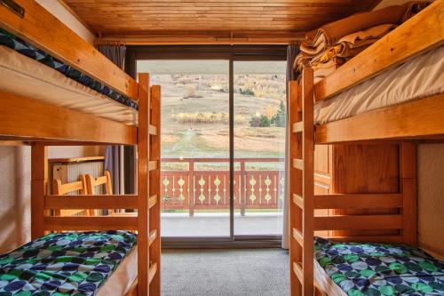 Dos literas en una habitación con ventana. en Eperon - Les 2 Alpes, en Les Deux Alpes