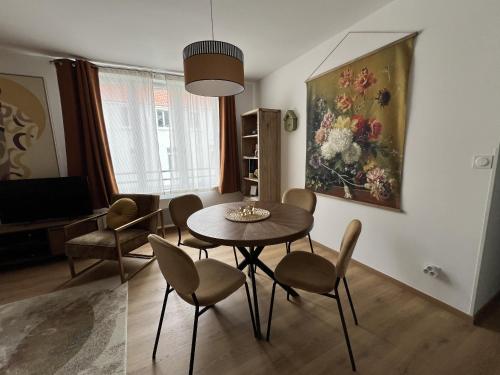 - un salon avec une table, des chaises et un tableau dans l'établissement Le Ginkgo Biloba, 2P Wifi, à Boulogne-sur-Mer