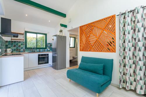 una sala de estar con una silla azul en la cocina en Appartement Iruba - Welkeys, en Saint-Pierre-dʼIrube