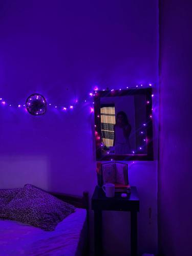 a purple room with a bed and a mirror at HOME HOSTEL ELLA private rooms only in Ella