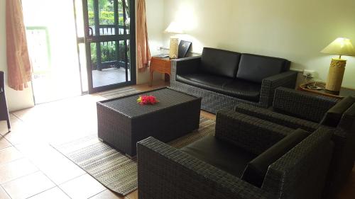 a living room with a couch and a chair at Grand West Villas in Nadi