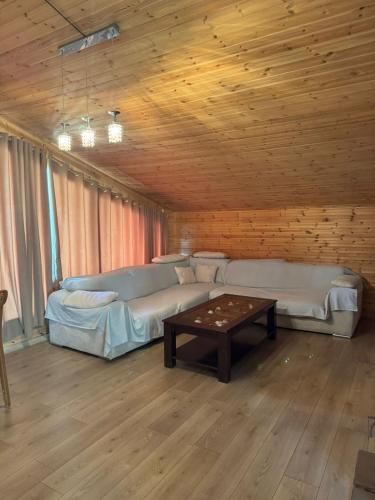 a living room with two beds and a coffee table at BioFarm Gramsh in Kodovjat