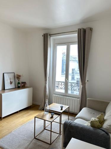 un salon avec un canapé et une fenêtre dans l'établissement Spacious apartment near Eiffel Grenelle F2, à Paris