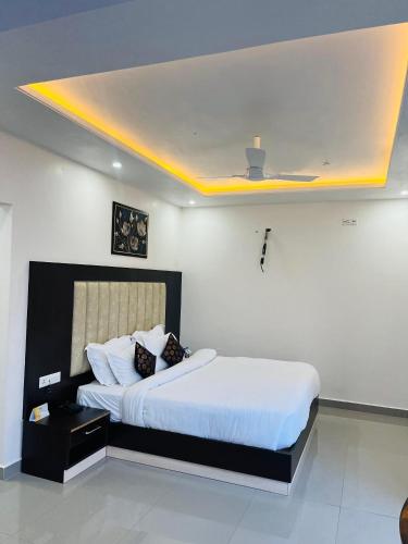 a bedroom with a large bed with a yellow ceiling at Aliza Inn And Suites By SRS Hotels in Dharamshala