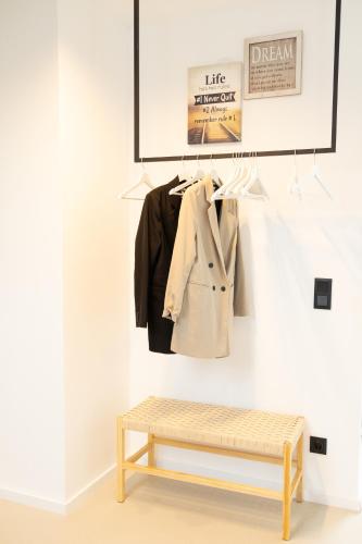 a coat hanging on a wall next to a bench at SI apartments - Smart Inn in Vienna