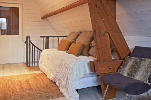 une chambre avec un lit avec des oreillers dessus dans l'établissement Maisons Normande à 5 minutes de Deauville, à Bonneville-sur-Touques