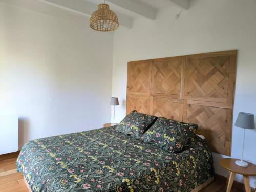 a bedroom with a bed with a green comforter at La maisonnette de Naomi in Coutances