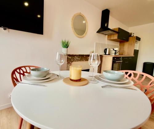 a white dining room table with two chairs and a white table at D-Day Suites in Carentan