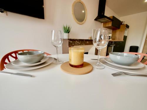 a table with two glasses and two bowls and plates at D-Day Suites in Carentan