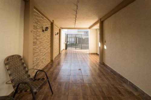 a empty hallway with a chair and a brick wall at Casa em Jardim Guaporé - DS1993 in Maringá