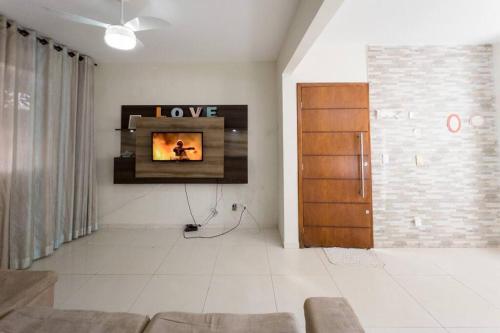 a living room with a tv on a wall at Casa em Jardim Guaporé - DS1993 in Maringá