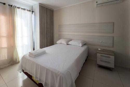 a bedroom with a white bed and a window at Casa em Jardim Guaporé - DS1993 in Maringá